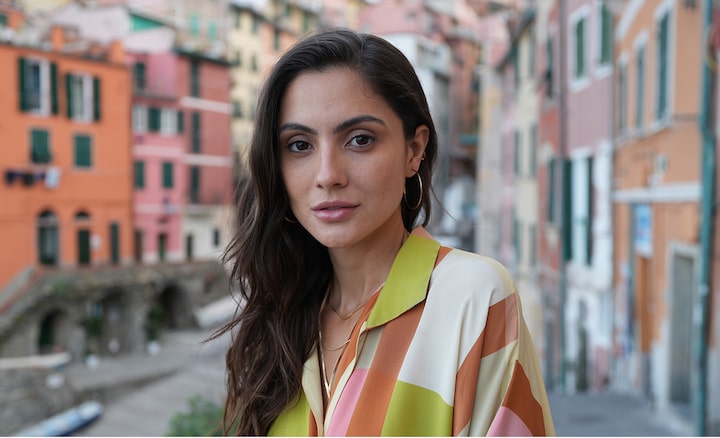 Example portrait image of a woman in focus with a wide angle background in depth with bokeh, showing that both wide angle and bokeh expressions can be achieved.