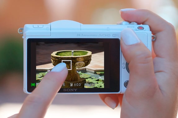 white camera taking picture of a fountain